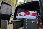 To jest prosta i funkcjonalna zabudowa camperowa typu „bed + skrzynie”