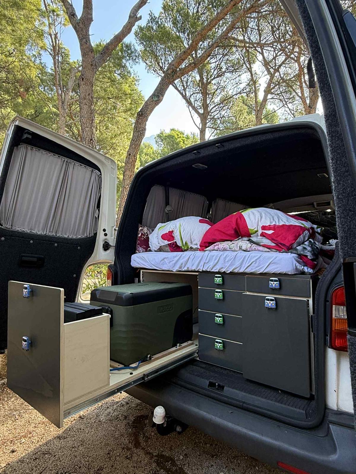 To jest prosta i funkcjonalna zabudowa camperowa typu „bed + skrzynie”